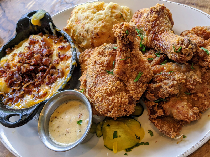 Fried chicken pieces on plate with mashed potatoes and biscuit