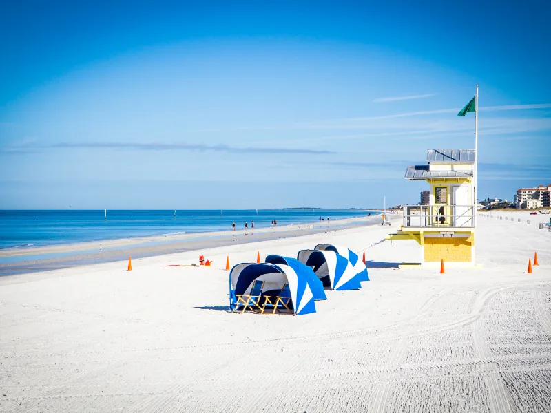 white sand Clearwater Beach with life guard shack and chairs with covers 